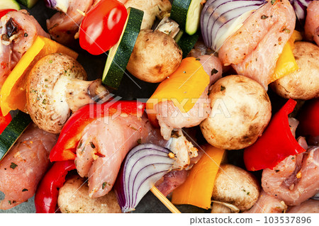 Raw meat skewers with vegetables. 103537896