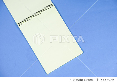 Open notepad on a blue background top view, space for text. Open notepad on a blue background top view, space for text. 103537926