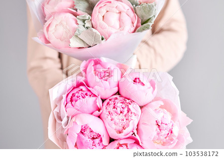 A bouquet of pink peonies in women's hands. Flower delivery. A beautiful bouquet of flowers as a gift for a holiday. A bouquet of pink peonies in women's hands. Flower delivery. A beautiful bouquet of flowers as a gift for a holiday. 103538172