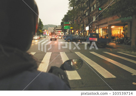 Riding a motorcycle on the road, subjective perspective, dusk 103539714