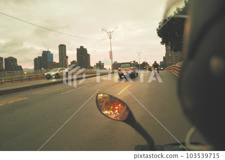 Riding a motorcycle on the road, subjective perspective, dusk 103539715