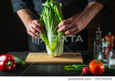 The chef makes a fresh napa cabbage salad. Preparation for slicing in the restaurant kitchen. Vegetable diet idea The chef makes a fresh napa cabbage salad. Preparation for slicing in the restaurant kitchen. Vegetable diet idea 103540045