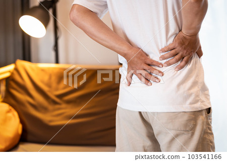Sad asian man having a backache after sleep,Stressed people suffering from low back pain,lumbar disc herniation,musculotendinous strain,touching his back with hands,health care,medical concept 103541166