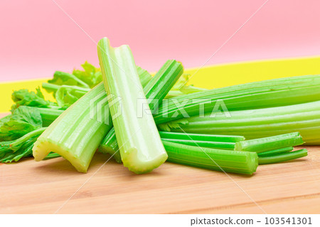 Fresh Celery Stem and Chopped Celery Sticks on Wooden Cutting Board Fresh Celery Stem and Chopped Celery Sticks on Wooden Cutting Board 103541301