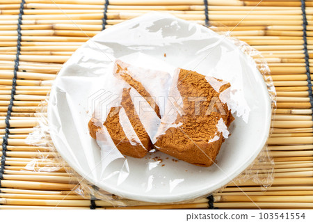 用保鮮膜（用大豆粉）包裹的蕨麻糬。帶百葉窗的夏季圖像。 103541554