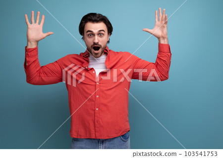 surprised caucasian brunette 30s man in a red shirt on a background with copy space surprised caucasian brunette 30s man in a red shirt on a background with copy space 103541753