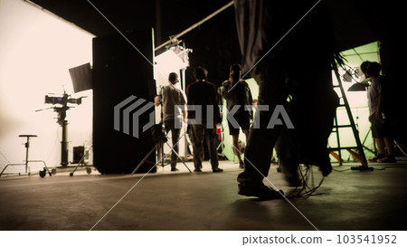 Blurry images of film crew working and filming in video production studio which using equipments such as cinema camera big film light and soft box or light diffusion panel. TV Commercial Film industry Blurry images of film crew working and filming in video production studio which using equipments such as cinema camera big film light and soft box or light diffusion panel. TV Commercial Film industry 103541952