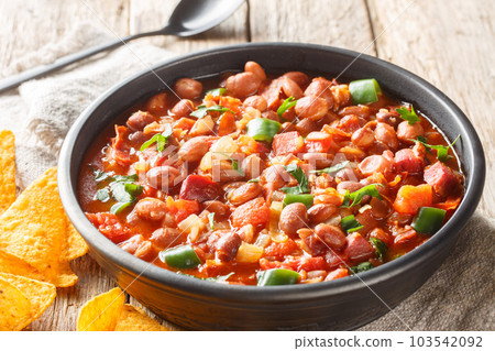 Frijoles charros is a traditional Mexican dish made of pinto beans stewed with onion, garlic, and bacon closeup on the bowl. Horizontal Frijoles charros is a traditional Mexican dish made of pinto beans stewed with onion, garlic, and bacon closeup on the bowl. Horizontal 103542092