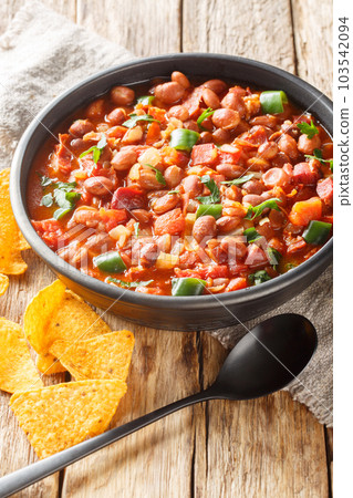 Mexican Charro Beans or Frijoles Charros with bacon, tomato, onions, ham, and jalapenos closeup on the bowl. Vertical 103542094