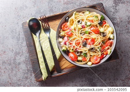 California pasta salad is a classic light Spaghetti salad with fresh vegetables such as zucchini, bell pepper, tomato, onion, and cucumber closeup. Horizontal top view 103542095