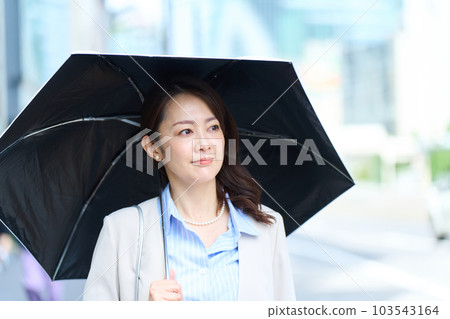 A woman going to work with a parasol A woman going to work with a parasol 103543164