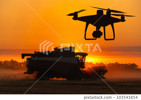Silhouettes of combine harvester and drone Silhouettes of combine harvester and drone 103543854