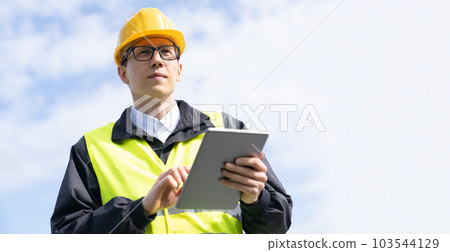 Engineer with digital tablet on a background of blue sky Engineer with digital tablet on a background of blue sky 103544129