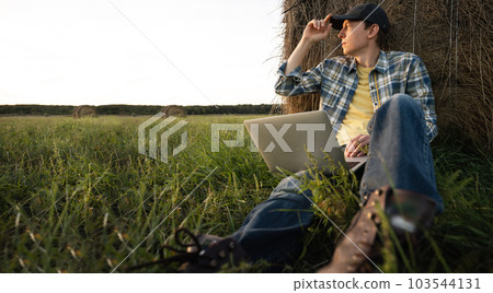 Farmer with laptop on the field. Smart farming and agriculture digitalization 103544131
