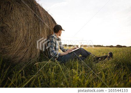 Farmer with laptop on the field. Smart farming and agriculture digitalization Farmer with laptop on the field. Smart farming and agriculture digitalization 103544133