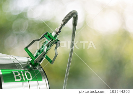 Biofuel filling nozzle with storage tank on a green background Biofuel filling nozzle with storage tank on a green background 103544203