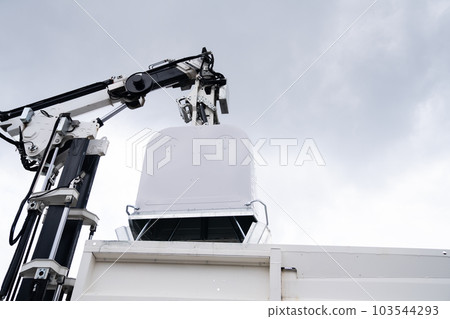 Garbage truck lifts street bin for recyclable waste 103544293