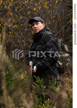 Hunter with a gun and a backpack in the forest. Hunter with a gun and a backpack in the forest. 103544495