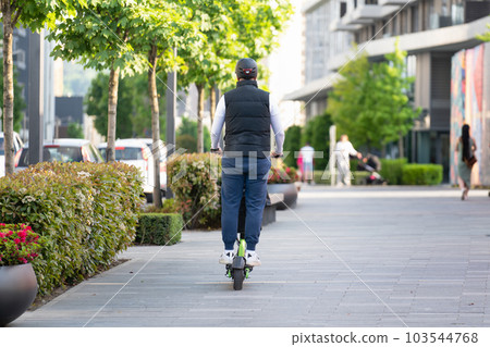 A man with electric scooter on the street. A man with electric scooter on the street. 103544768