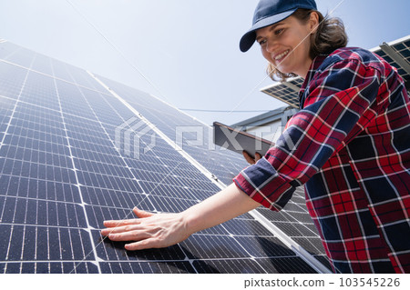 Woman with tablet touching solar panel 103545226