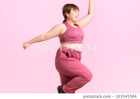 Exercising plump young woman plus size model image Exercising plump young woman plus size model image 103545384