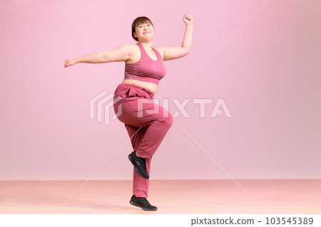 Exercising plump young woman plus size model image Exercising plump young woman plus size model image 103545389