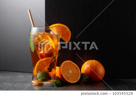 Iced tea or a summer refreshing drink with ice, mint, and orange. Iced tea or a summer refreshing drink with ice, mint, and orange. 103545529