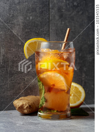 Iced tea with mint, ginger, and lemon on a grey background. 103545535