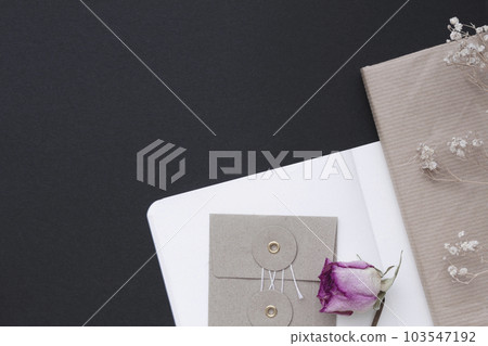 筆記本、信封、書籍、玫瑰、幹滿天星花、黑色背景 103547192