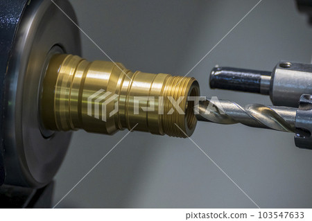 The CNC lathe machine boring cutting the brass material parts by drill tool. The CNC lathe machine boring cutting the brass material parts by drill tool. 103547633