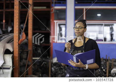 African american worker woman wear spectacles crossed arms holding clipboard standing in factory 103547728