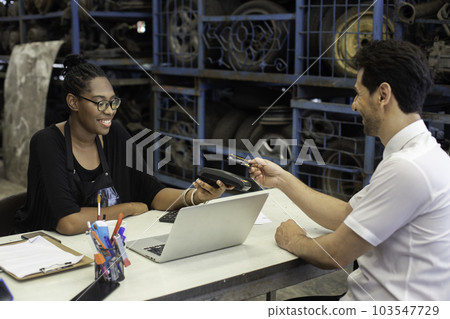 Female African American car auto parts owner Accepting credit card payments from customers. 103547729