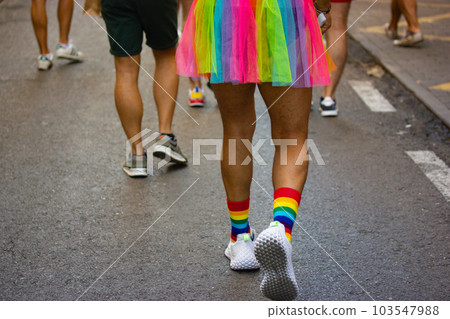 Man wearing rainbow LGBT skirt walking on city street at Gay parade. Pride month 103547988