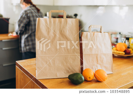 Two Food craft bags on the wooden table on sunny day. Delivery in any weather around the clock to the client. Fast food eco packaging with big breakfast or diner set with fruits Two Food craft bags on the wooden table on sunny day. Delivery in any weather around the clock to the client. Fast food eco packaging with big breakfast or diner set with fruits 103548895