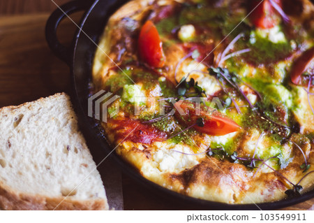 Fried eggs with tomato and ham in pan. Served breakfast table. Omelette with tomato and bread. Spanish tortilla. Eggs with pesto and vegetables. Ready to eat food. Healthy dinner. Fried eggs with tomato and ham in pan. Served breakfast table. Omelette with tomato and bread. Spanish tortilla. Eggs with pesto and vegetables. Ready to eat food. Healthy dinner. 103549911