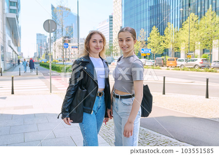 Two smiling female students looking at camera, urban modern background 103551585