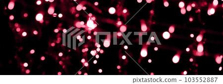 Blurry garland lights on a dark background. Festive Christmas and New Year background. Soft focus. Image toned in color of the year 2023 viva magenta Blurry garland lights on a dark background. Festive Christmas and New Year background. Soft focus. Image toned in color of the year 2023 viva magenta 103552887