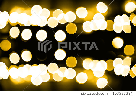 Blurry garland lights on a dark background. Festive Christmas and New Year background. Soft focus 103553384