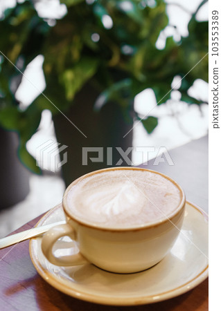 Coffee cup with a heart pattern in a blue cup on a wooden background Coffee cup with a heart pattern in a blue cup on a wooden background 103553389