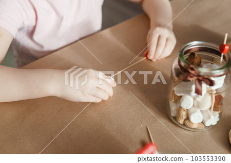 Children's hands collect a sweet gift for Valentine's Day. A gift for the holiday, a video blog entry. 103553390