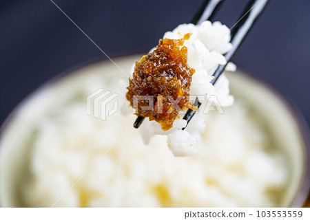 剛煮好的米飯,上面放著辣味噌,拿著筷子 剛煮好的米飯,上面放著辣味噌,拿著筷子 103553559