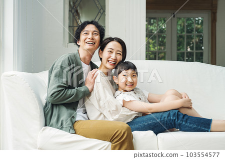 Portrait of a family sitting on a sofa in the living room at home Portrait of a family sitting on a sofa in the living room at home 103554577