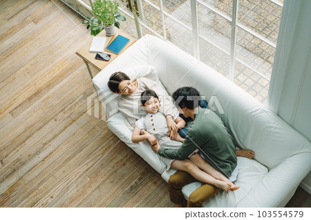 Family playing on the sofa in the living room at home 103554579