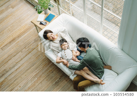 Family playing on the sofa in the living room at home 103554580