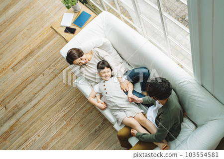 家人在家裡客廳的沙發上玩耍 家人在家裡客廳的沙發上玩耍 103554581