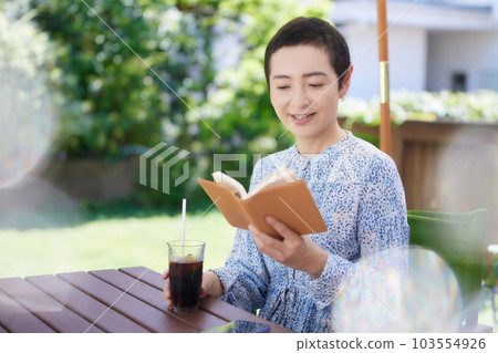 在開放式咖啡館看書的中年婦女 103554926