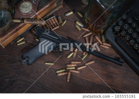 Adventure fiction - old retro vintage typewriter and vintage gun with ammunitions. 103555191