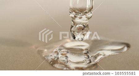 The texture of serum or oil with a pipette on a beige background. The texture of serum or oil with a pipette on a beige background. 103555581