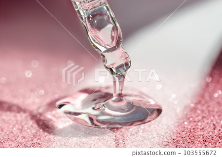Cosmetic pipette with a pink on dark background. Cosmetic pipette with a pink on dark background. 103555672