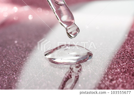 Cosmetic pipette with a pink on dark background. Cosmetic pipette with a pink on dark background. 103555677